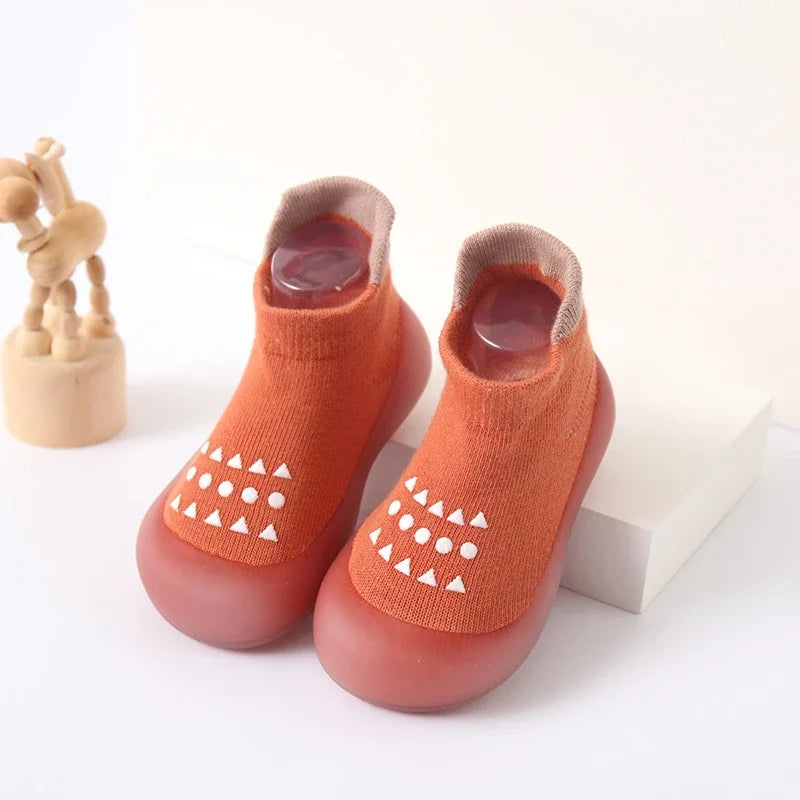 Zapato infantil con calcetín y suela de goma suave.