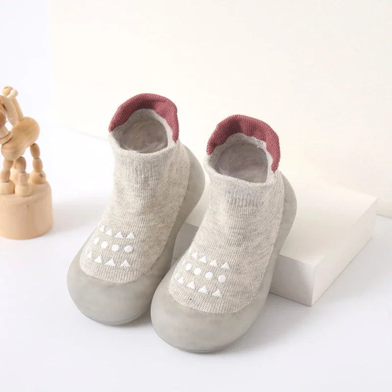 Zapato infantil con calcetín y suela de goma suave.