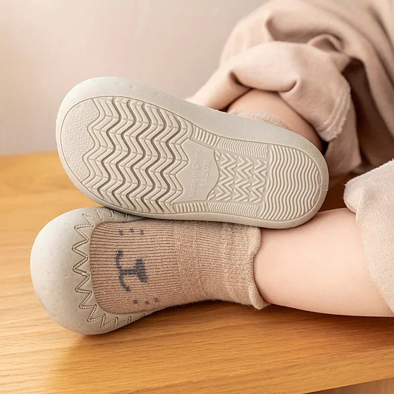 Zapato infantil con calcetín y suela de goma suave.